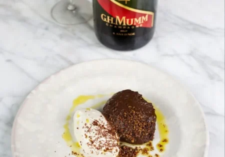 A bottle of G.H.Mumm Grand Cordon Brut next to a plate of Chocolate Mousse & Chantilly