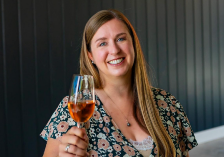 Mumm Napa winemaker Tami Lotz raising a glass of rosé sparkling wine and smiling