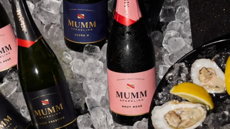 Selection of Mumm Napa sparkling wine bottles including Cuvée M, Brut Prestige, and Brut Rosé on ice next to a plate of oysters and lemon wedges