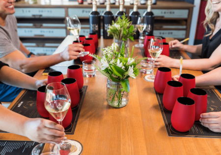 A group drinks wines from dark red cups designed to disguise their contents