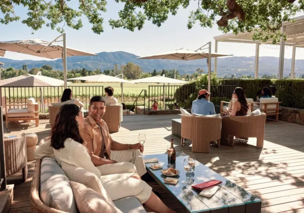 A couple sitting outside on the Oak Terrace of the Mumm Napa winery, enjoying glasses of sparkling wine